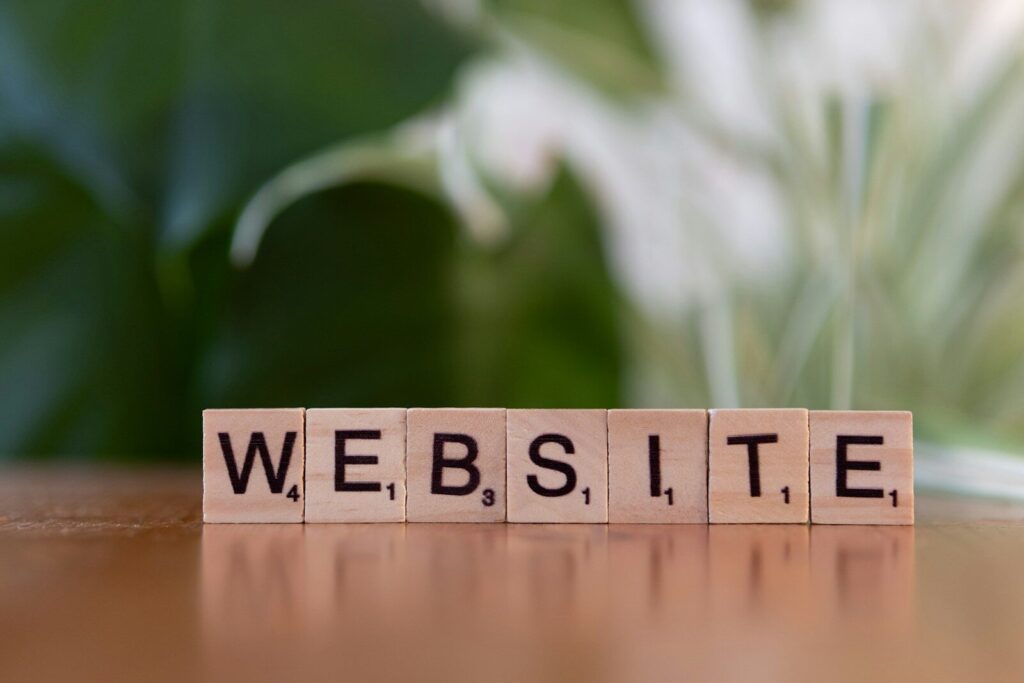 A wooden block spelling the word website on a table